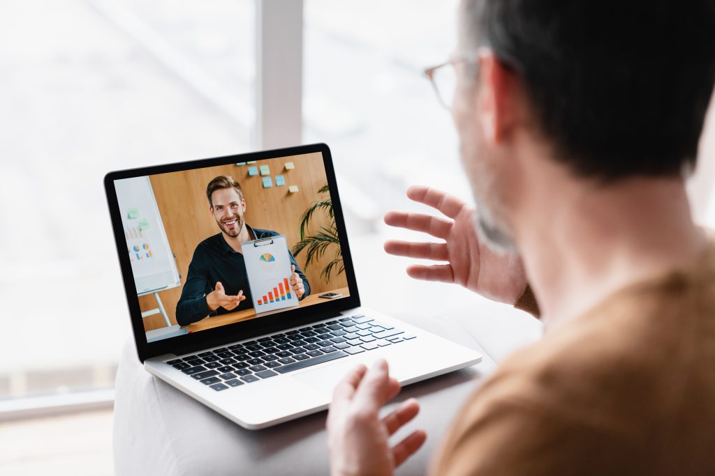 Caucasian businessman boss CEO freelancer e learning having videocall conference conversation meeting online on laptop with colleague teacher tutor showing charts remotely on distance watching webinar
